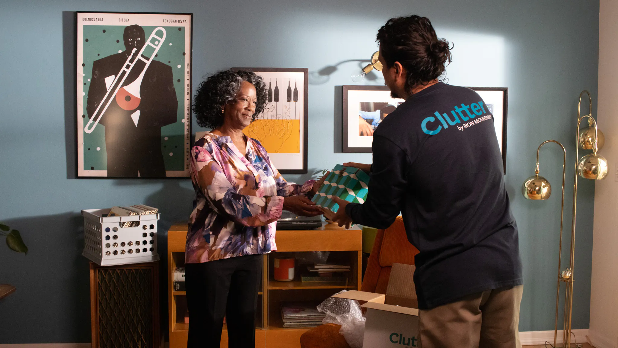 a photo of a woman handing a box to a clutter employee